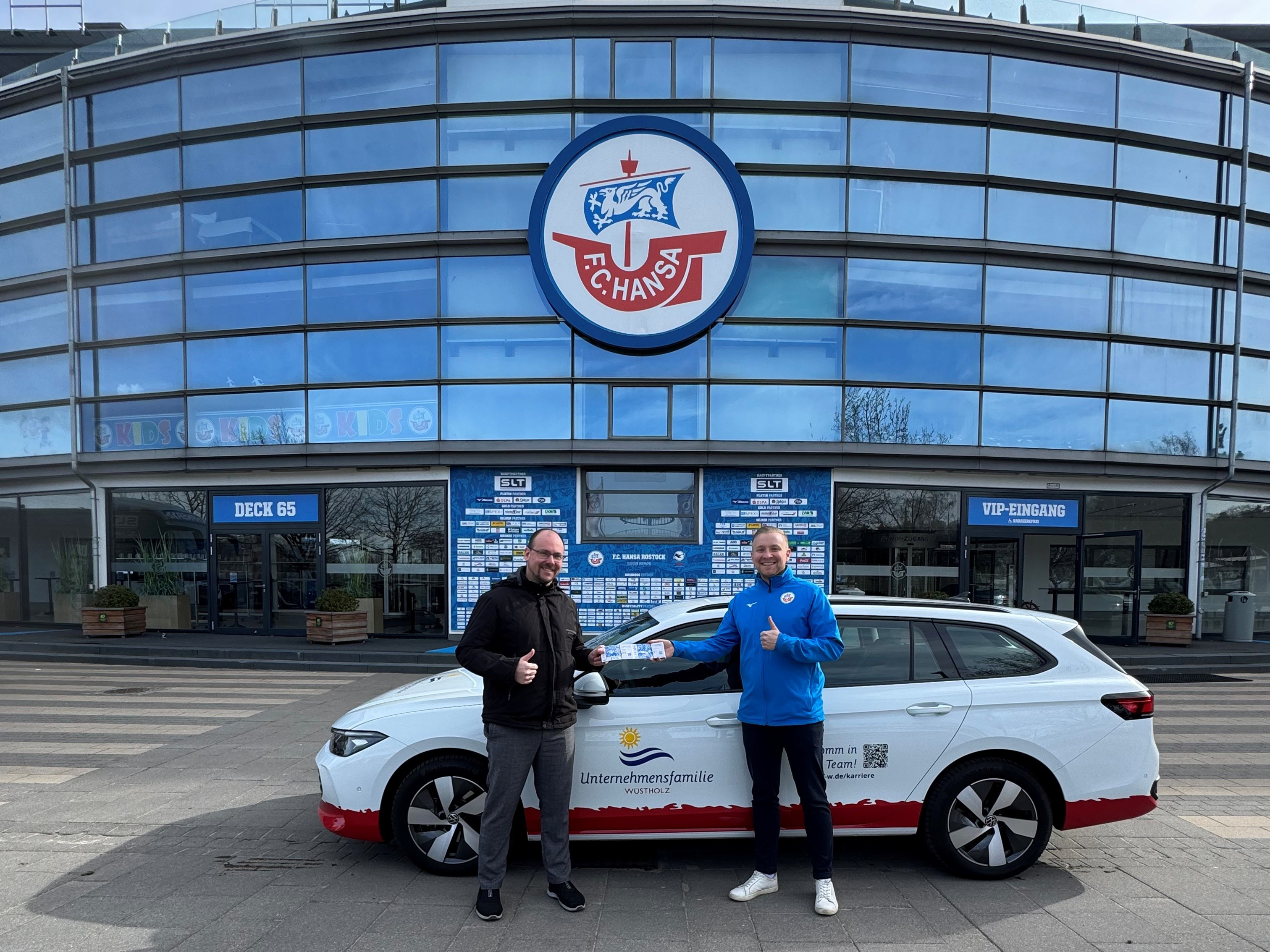 Marketingbeauftragter der Unternehmensfamilie Wüstholz René Becke und Mitarbeiter Partnermanagement des F.C. Hansa Rostock Bastian Stemmann bei der Kartenübergabe